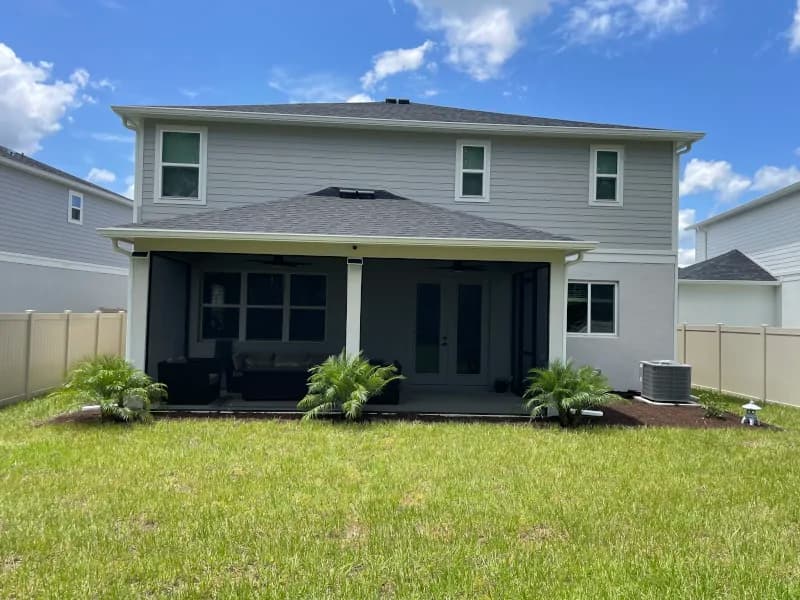 Back of a two-story home with a new planting bed along the lanai