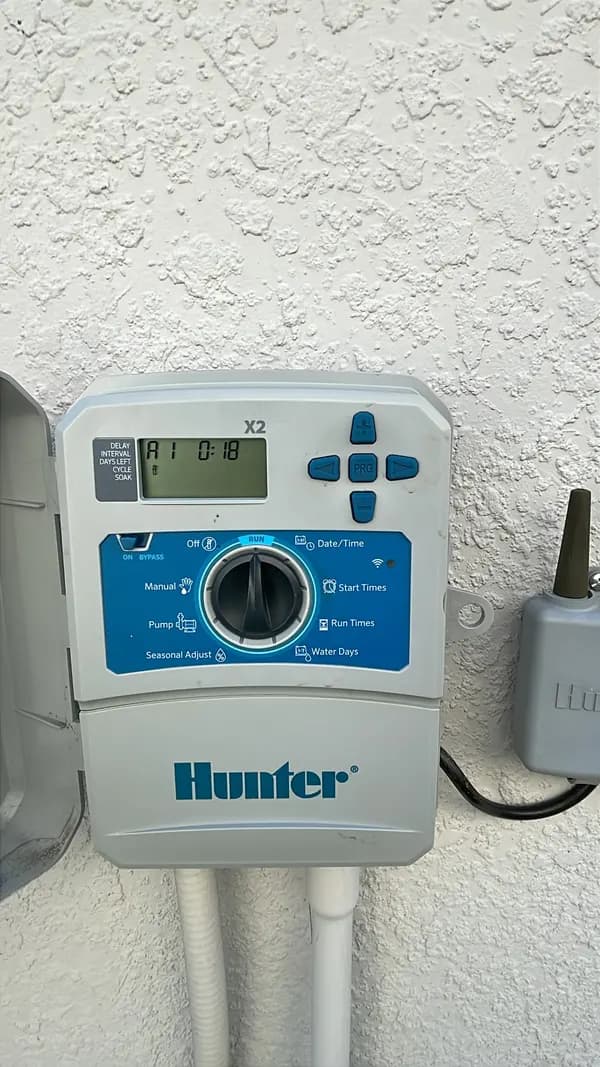 Hunter sprinkler controller mounted on a stucco wall
